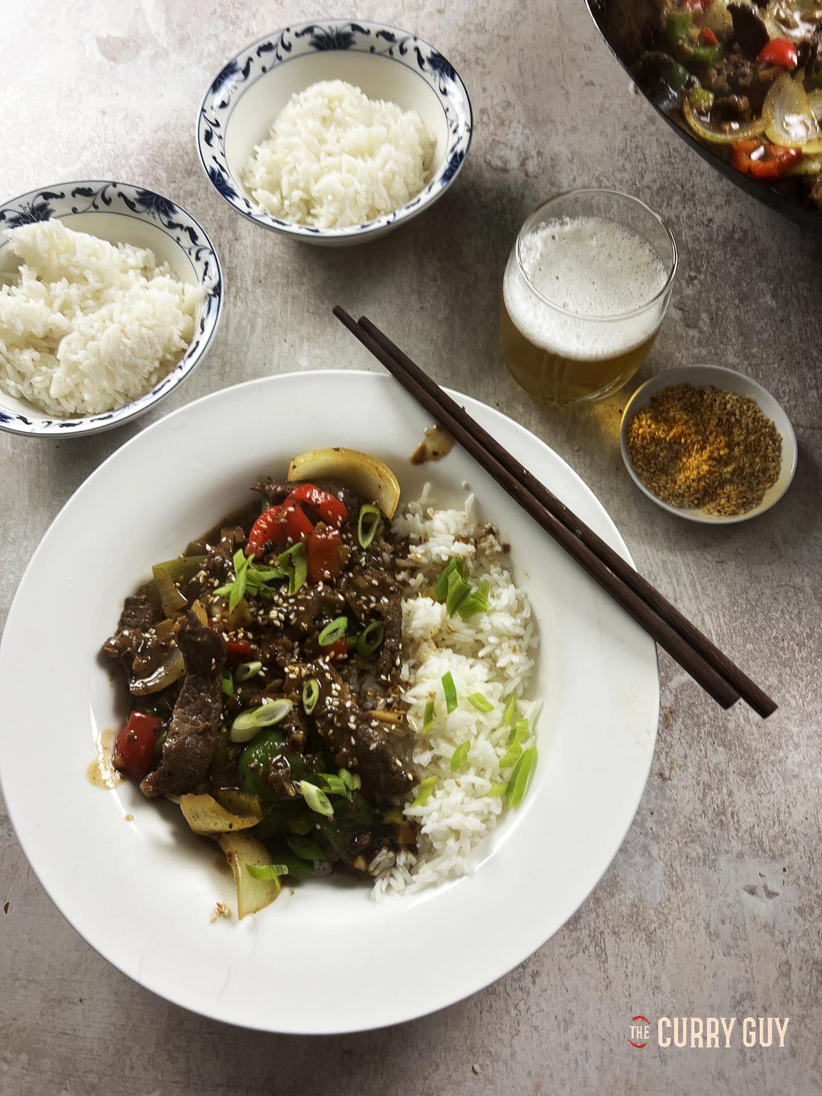 Beef in black bean sauce served at the table with rice.
