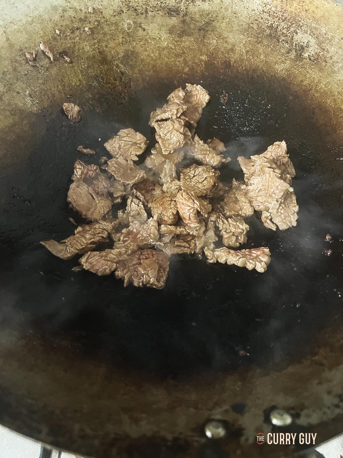 Frying the marinated meat.