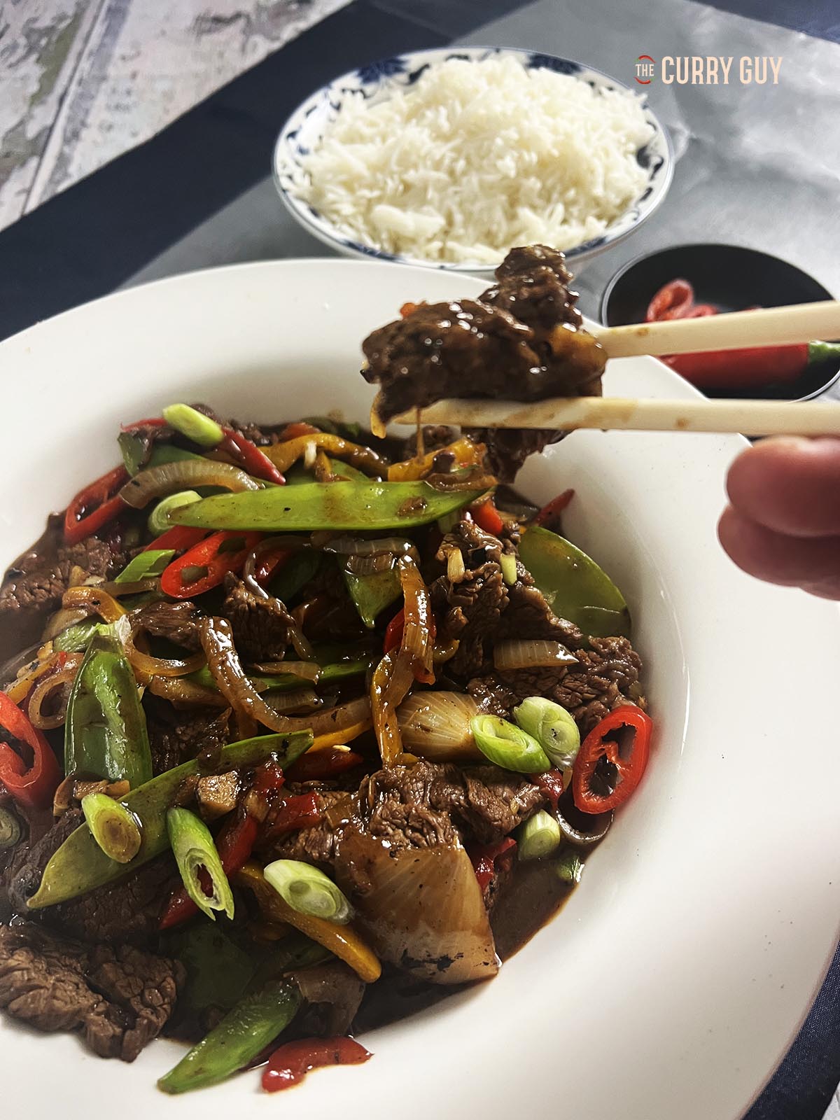 Holding a piece of the beef with chopsticks.