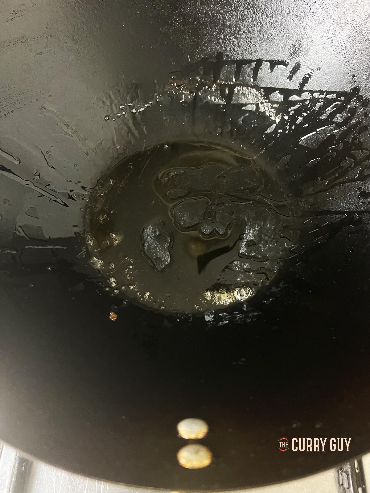 Heating sesame oil in a wok.