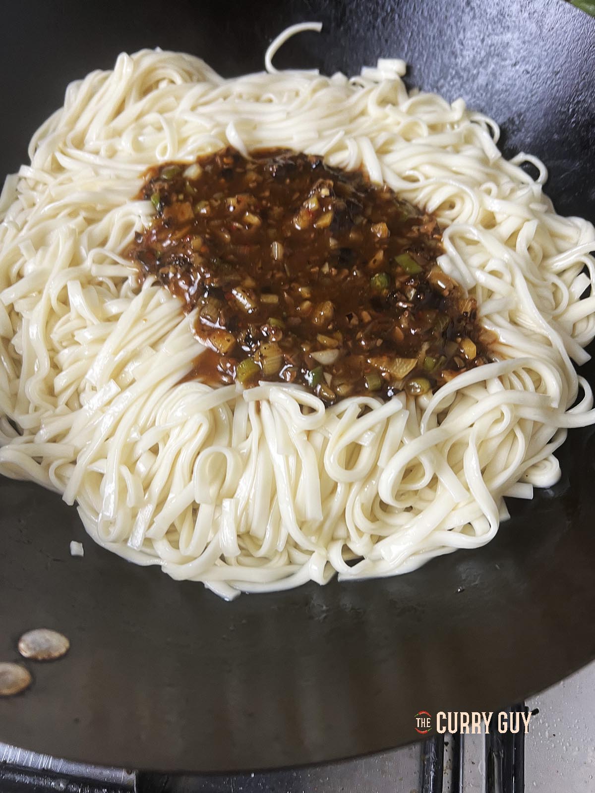 Adding the black bean sauce to the wok.