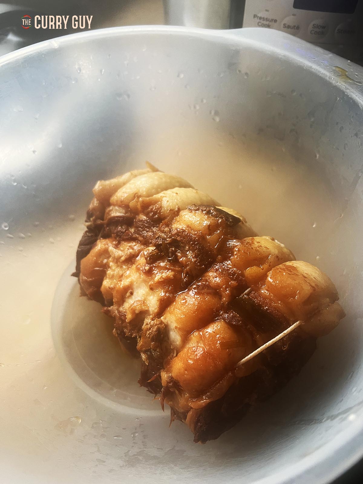 Chashu pork resting in a bowl before slicing.