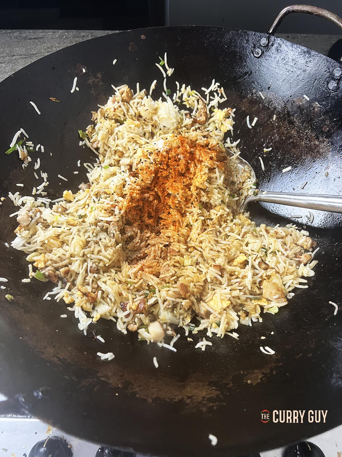 Tossing the ingredient in the wok around to coat.