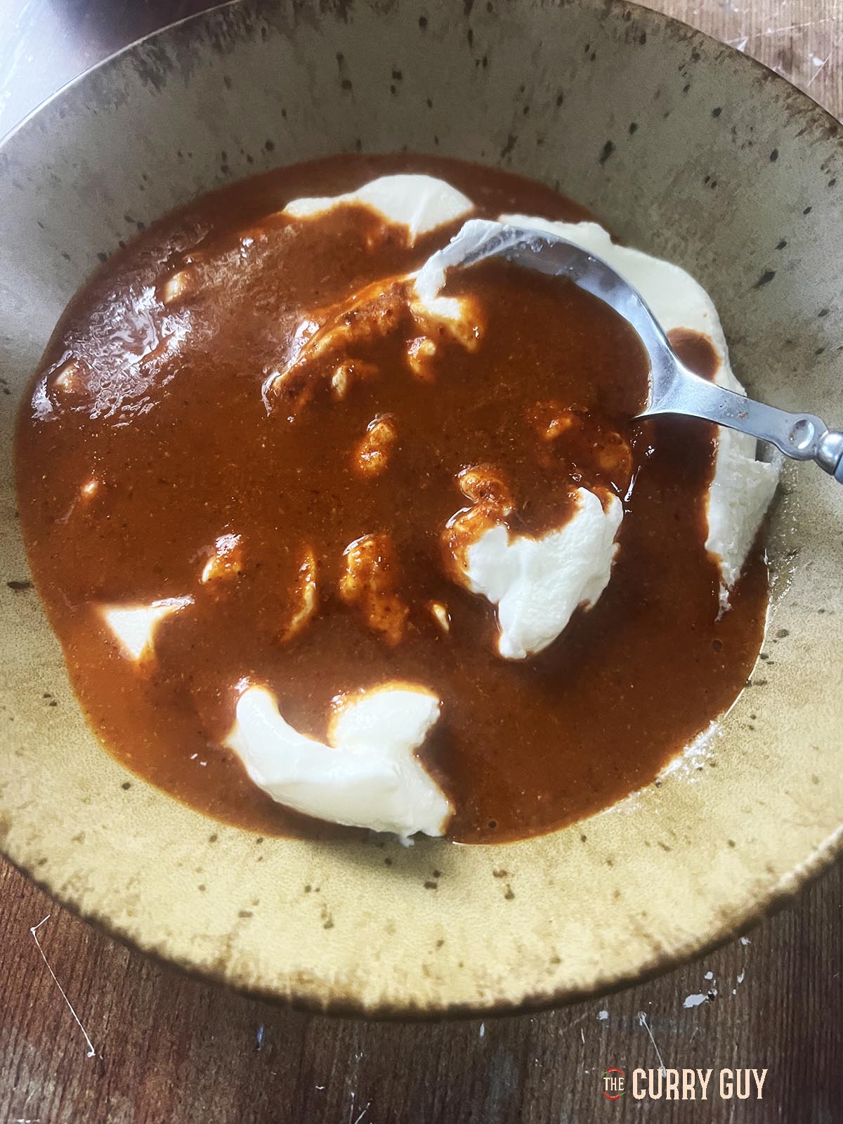 Mixing the yoghurt with the chilli sauce from the blender.