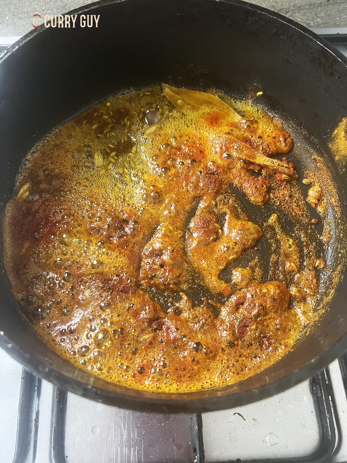 Infusing the whole spices and ground spices in oil over a medium-high heat.