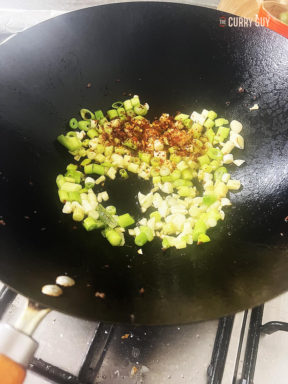 Frying the aromatic ingredients in the wok.