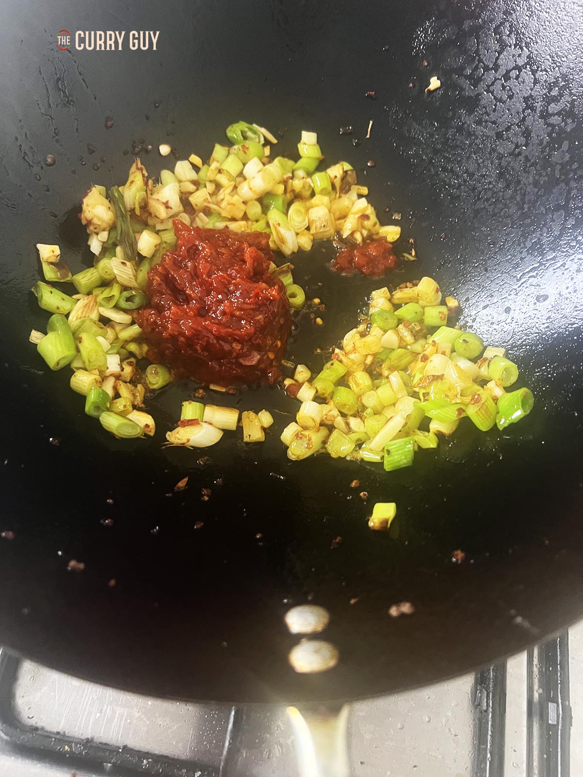 Adding the doubanjiang to the wok.