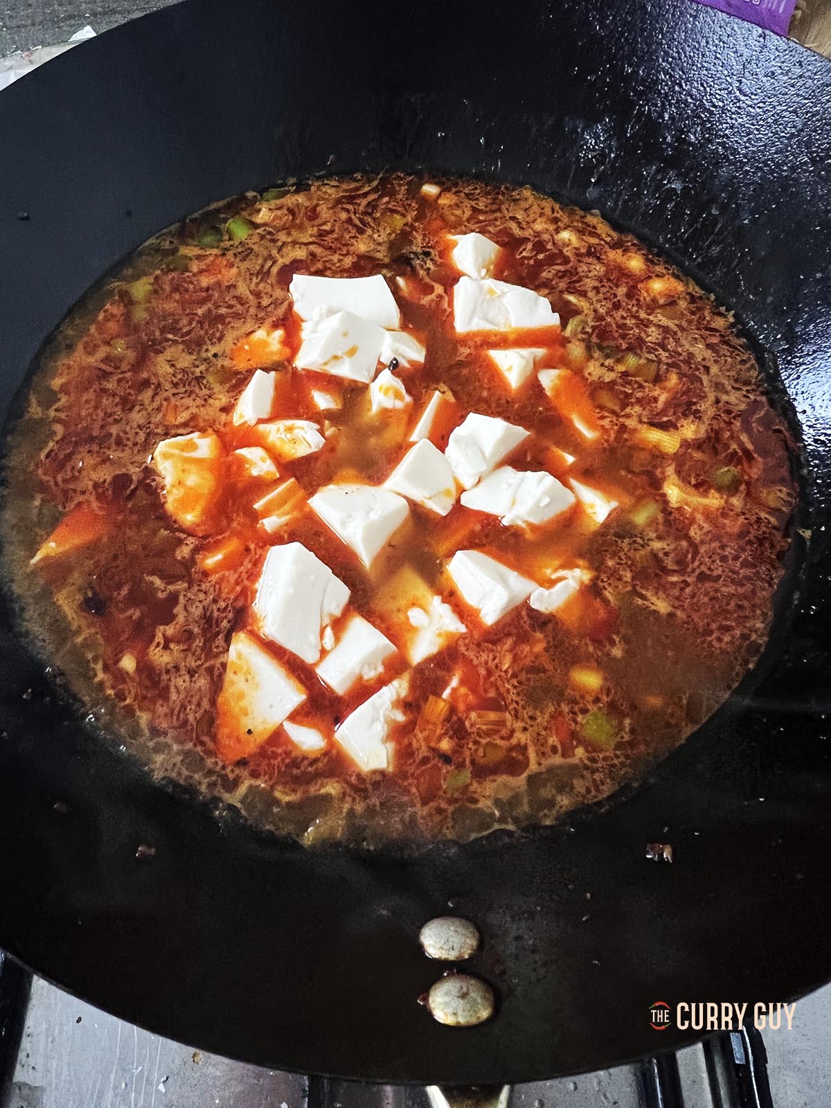 Adding tofu to the wok.