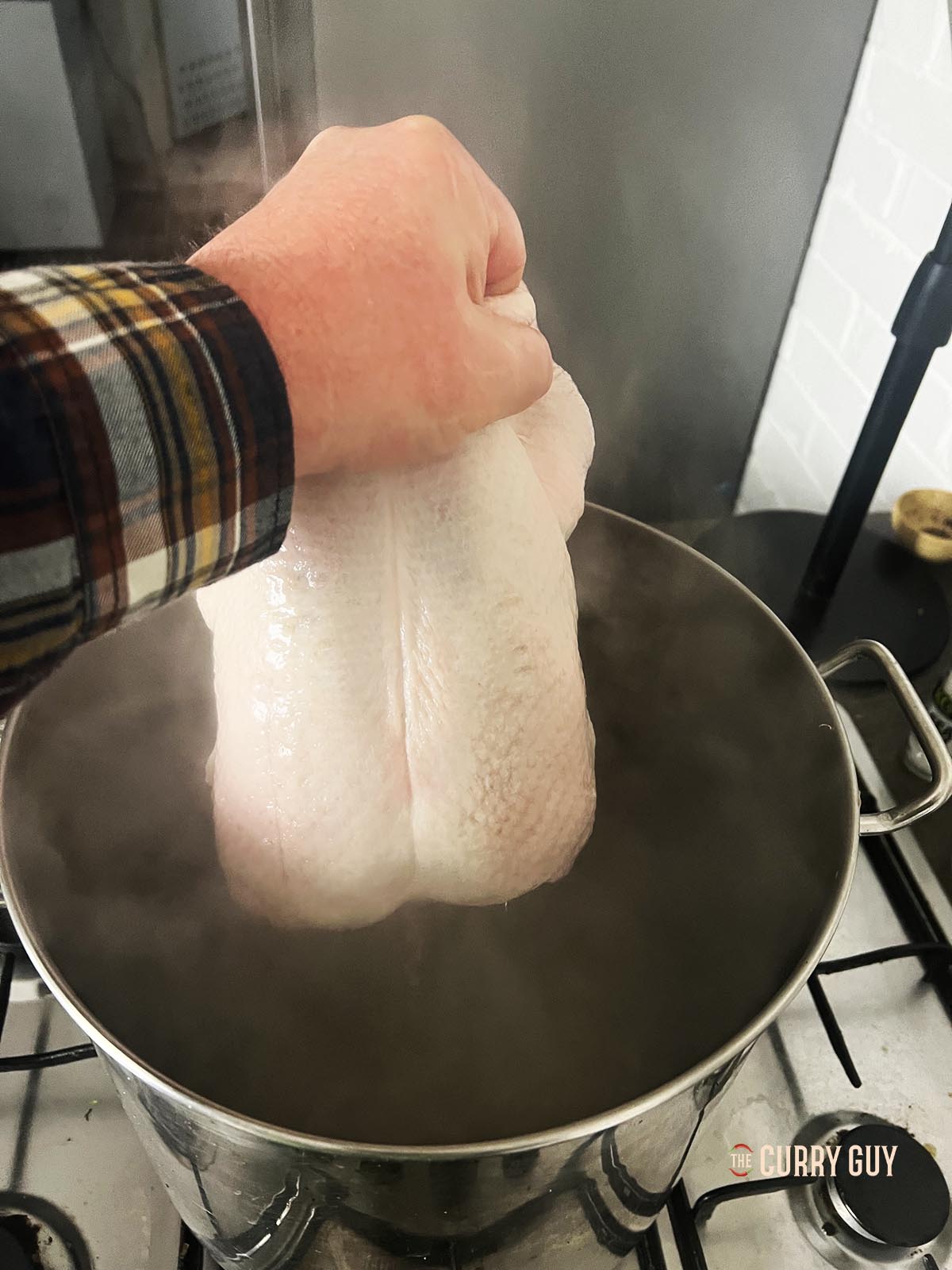 Lowering the duck into boiling water. 