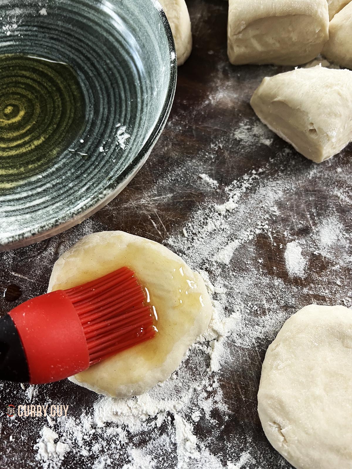 Brushing a dough ball with sesame oil.