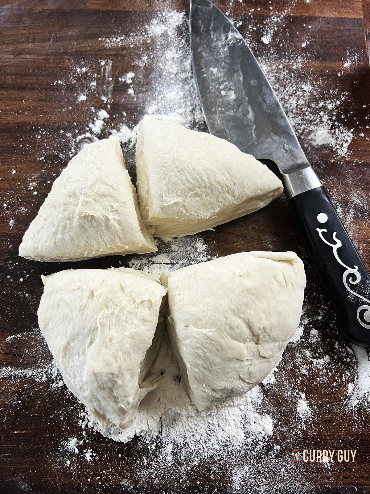 The kneaded dough ball sliced into 4 equal pieces.
