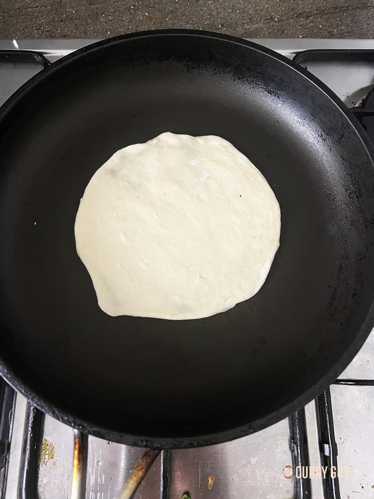Adding a pancake to a pan over a medium heat.