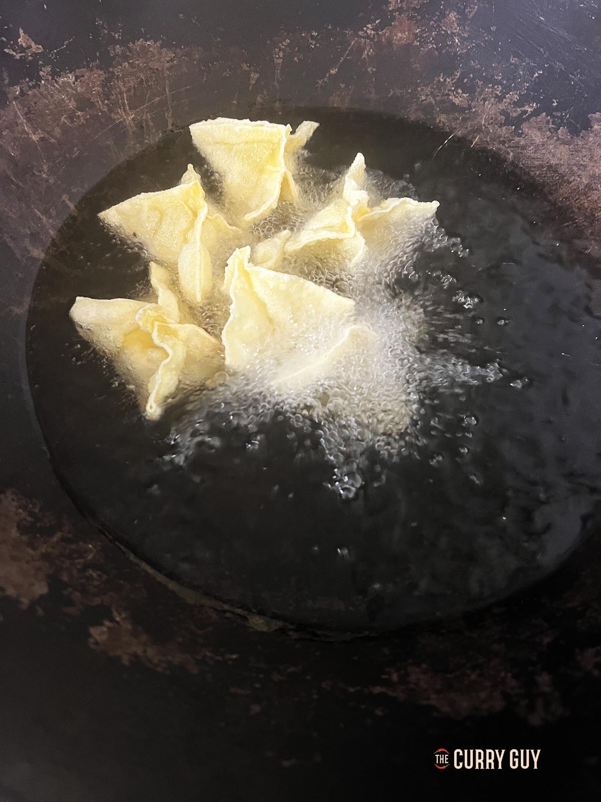 Frying one batch of the shrimp rangoon in hot oil.