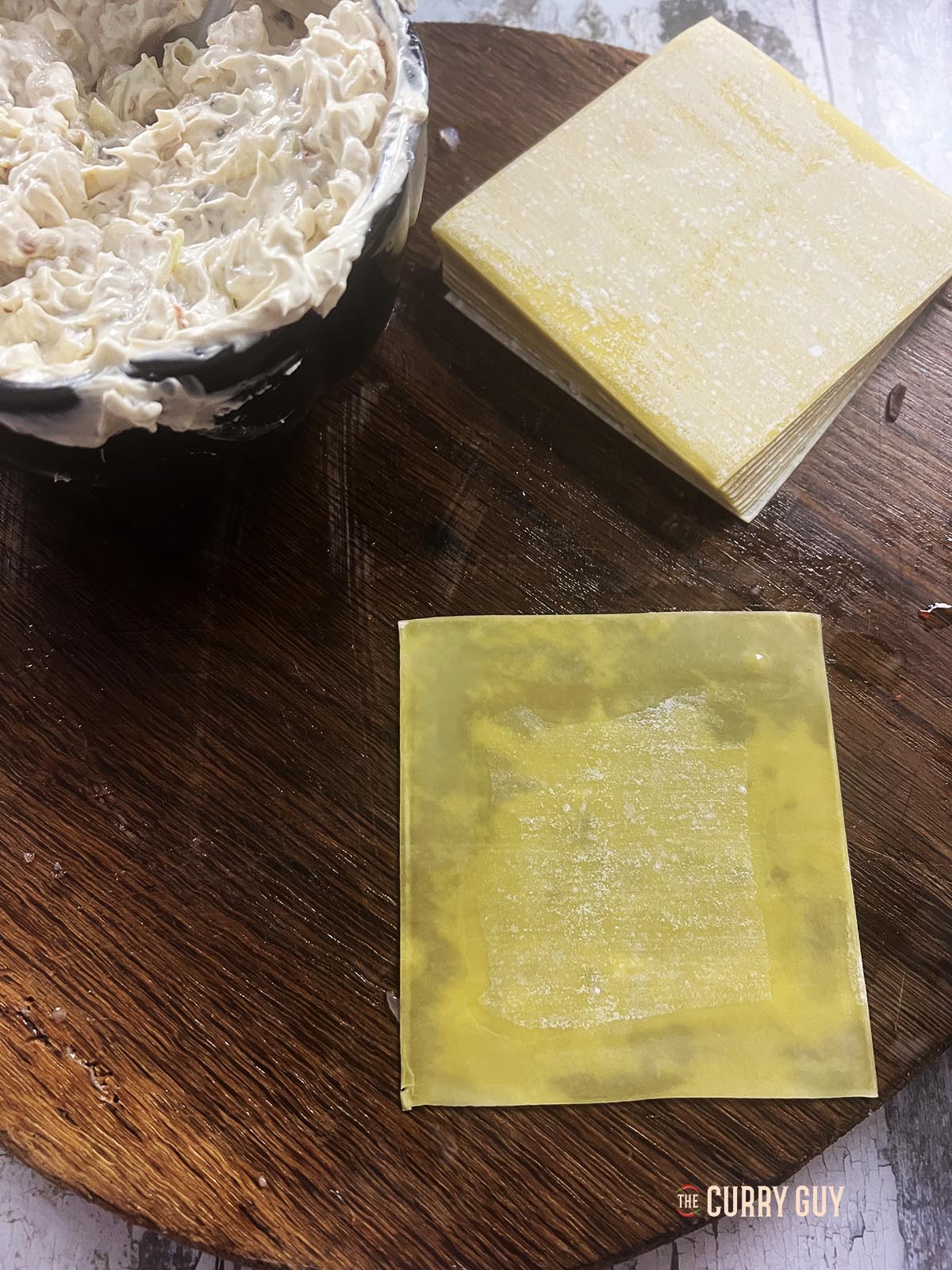 Wetting the sides of a wonton wrapper with water.