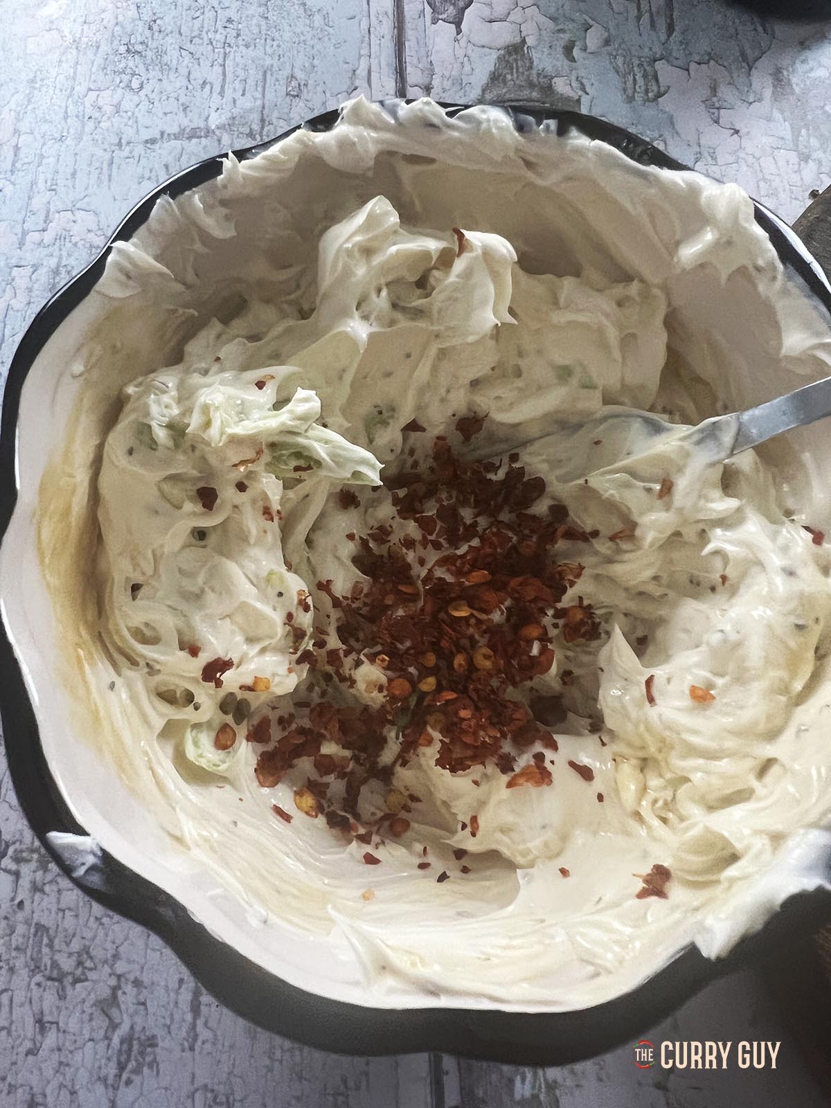 Whisking the cream cheese with the wet and dry ingredients.
