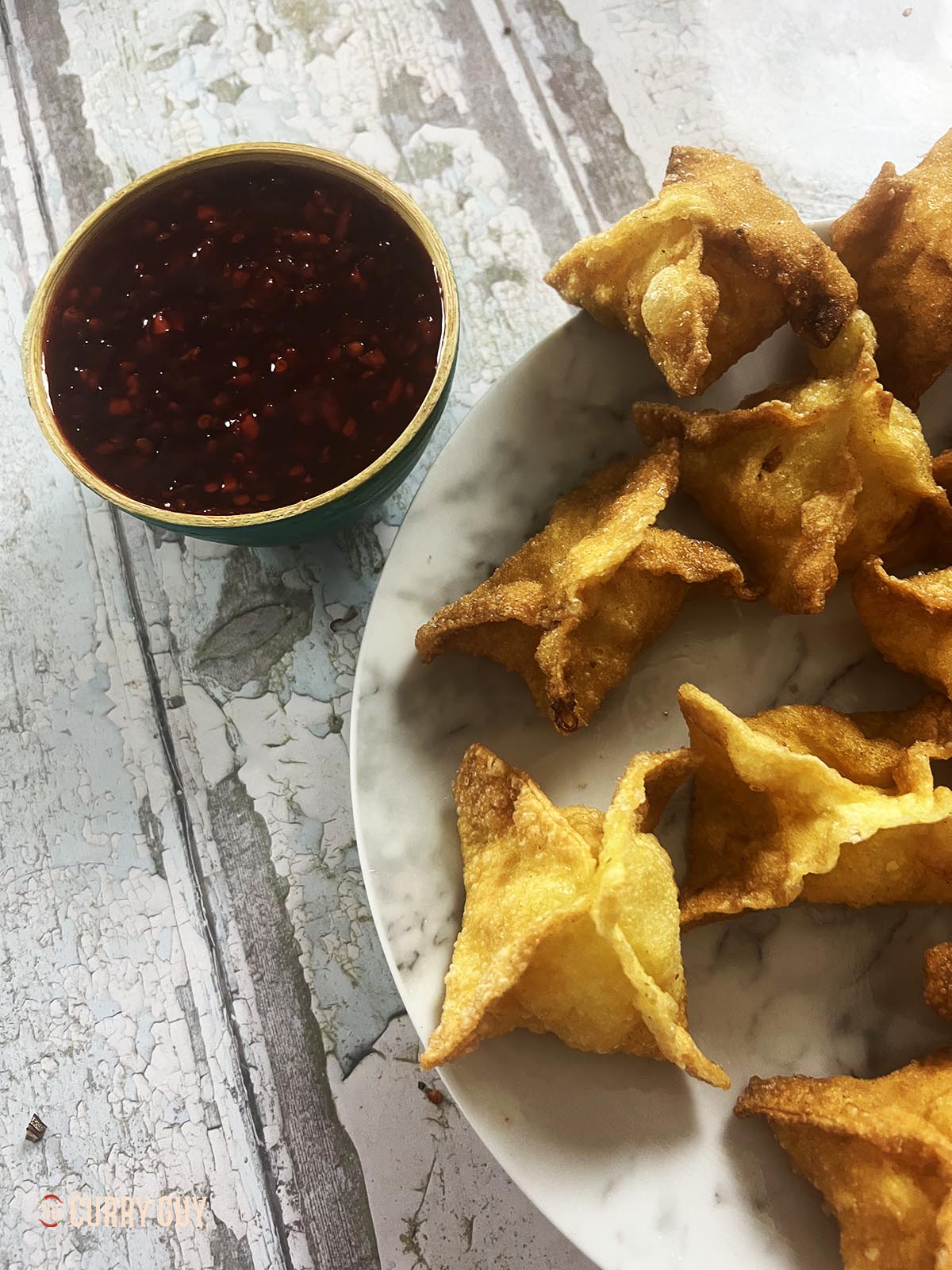 Shrimp rangoon on a serving plate with sweet chili sauce.