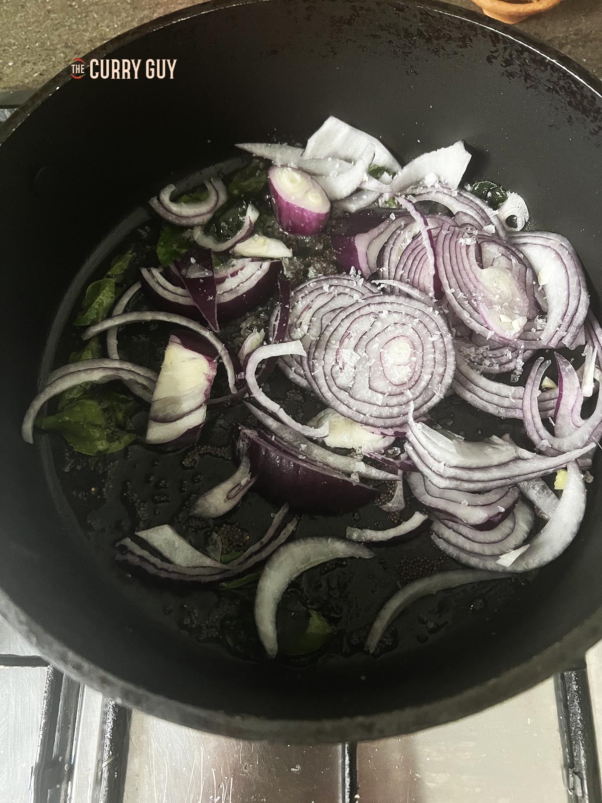 Adding the red onions to the pan.
