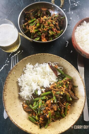 The green beans curry south Indian style served on a plate with basmati rice.