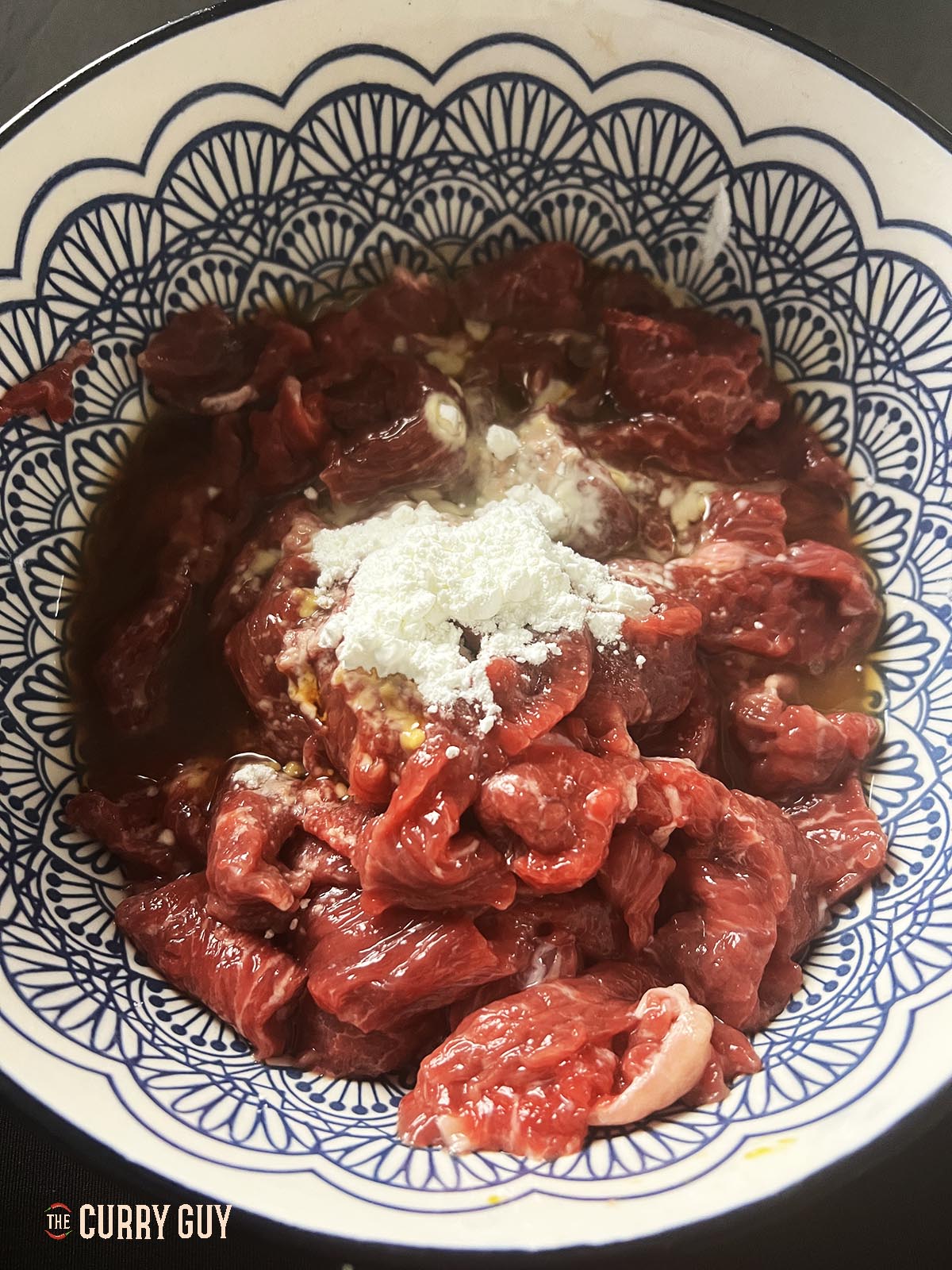 Adding the marinade ingredients to the meat.