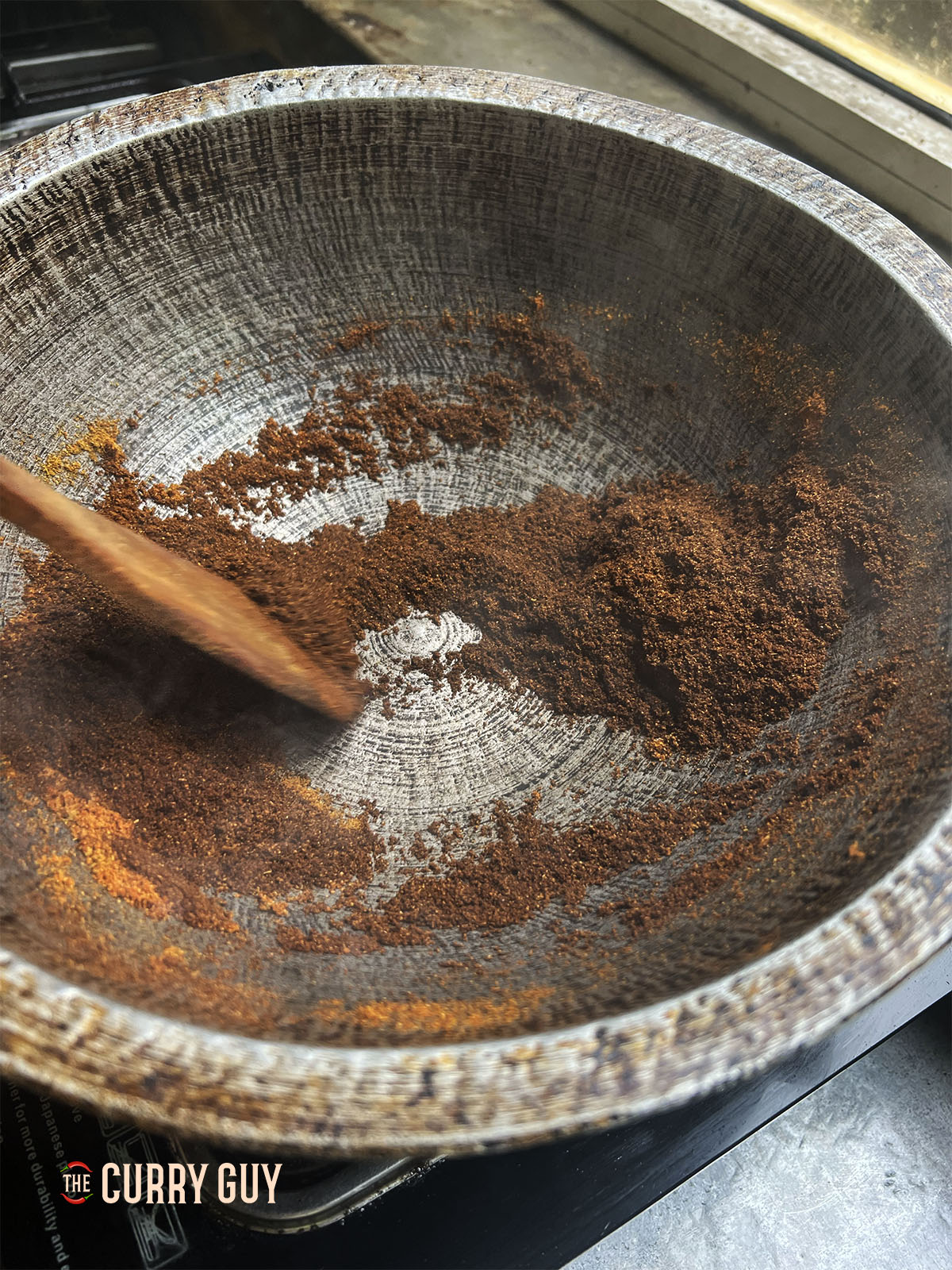Roasting the curry powder and chilli powder in a dry pan to darken.