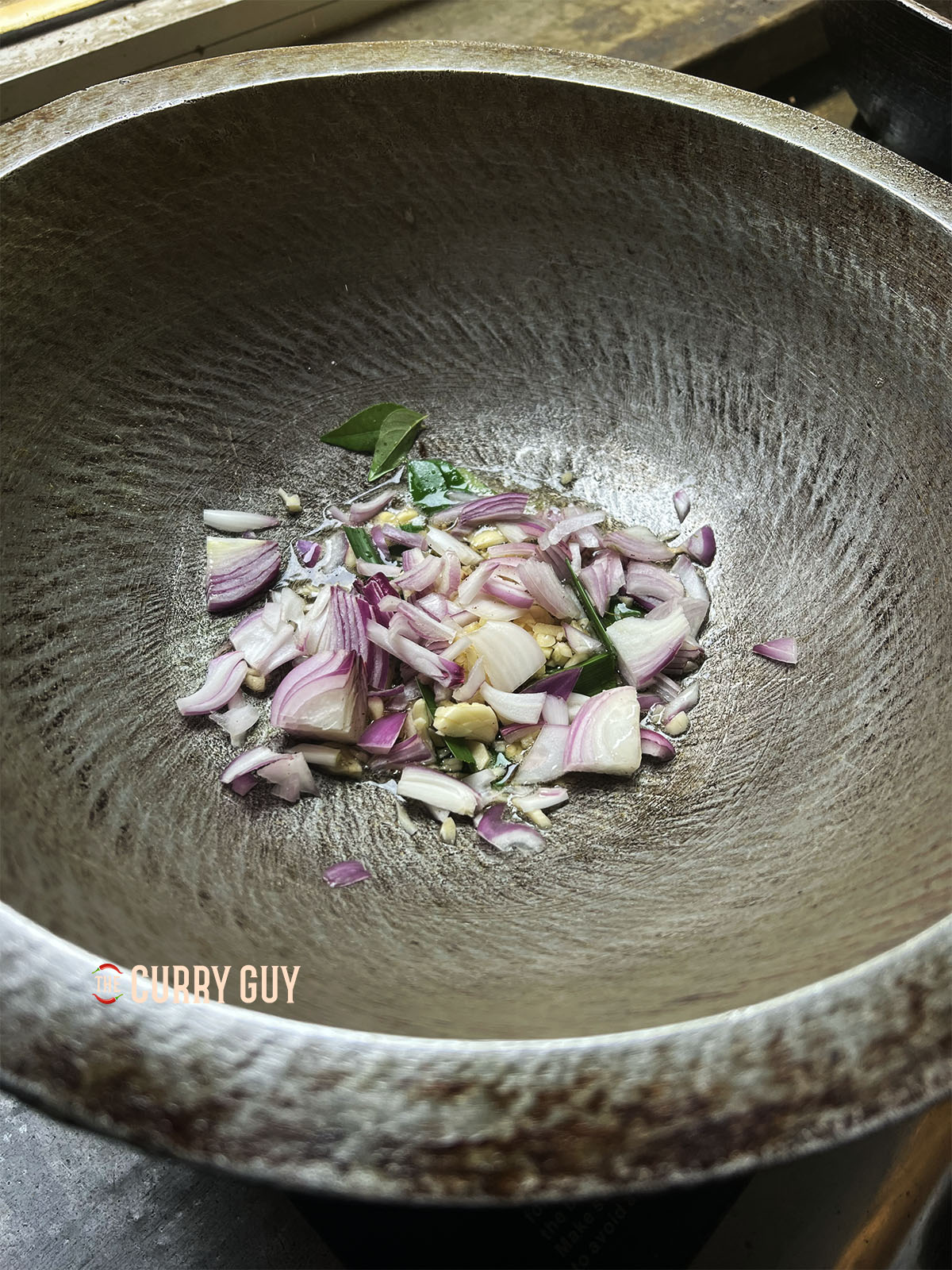 Frying onions, curry leaves, chillies, garlic and ginger in coconut oil.