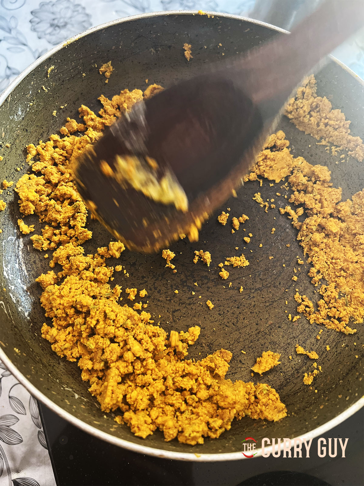 Toasting the gram flour mixture in the pan.