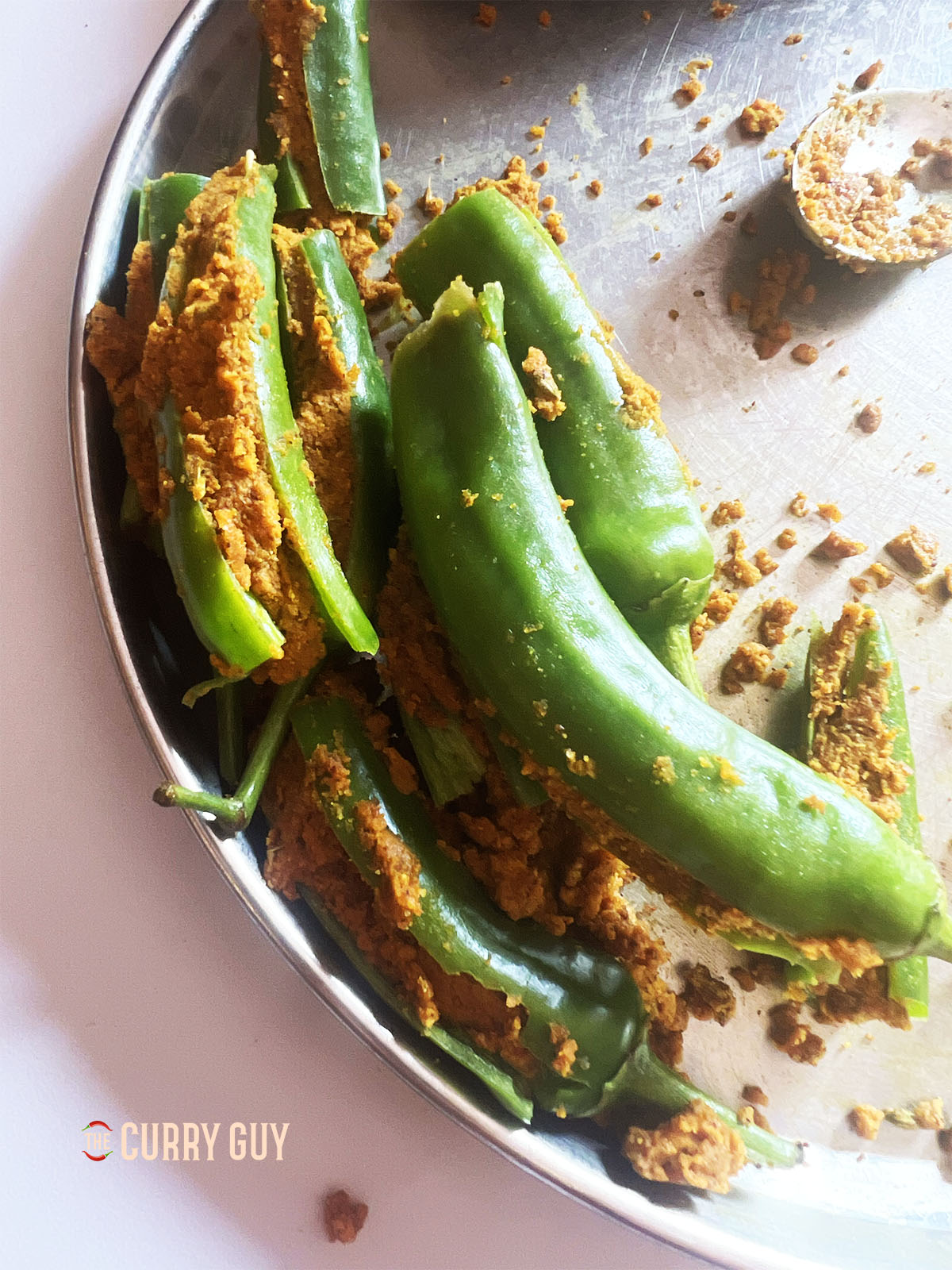 Slicing the chillies and stuffing them with the gram flour stuffing.