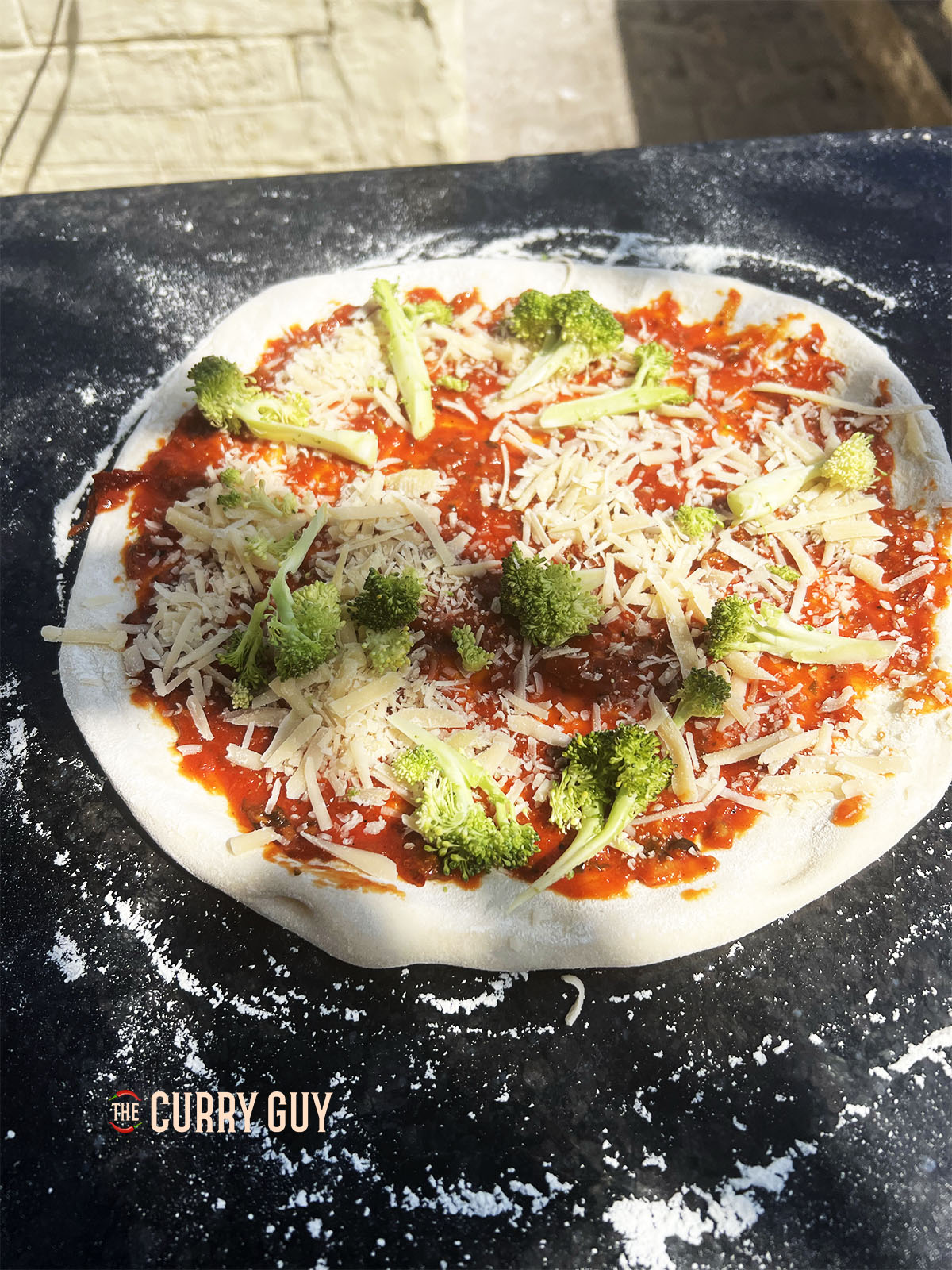 Placing the toppings on the naan pizza dough.