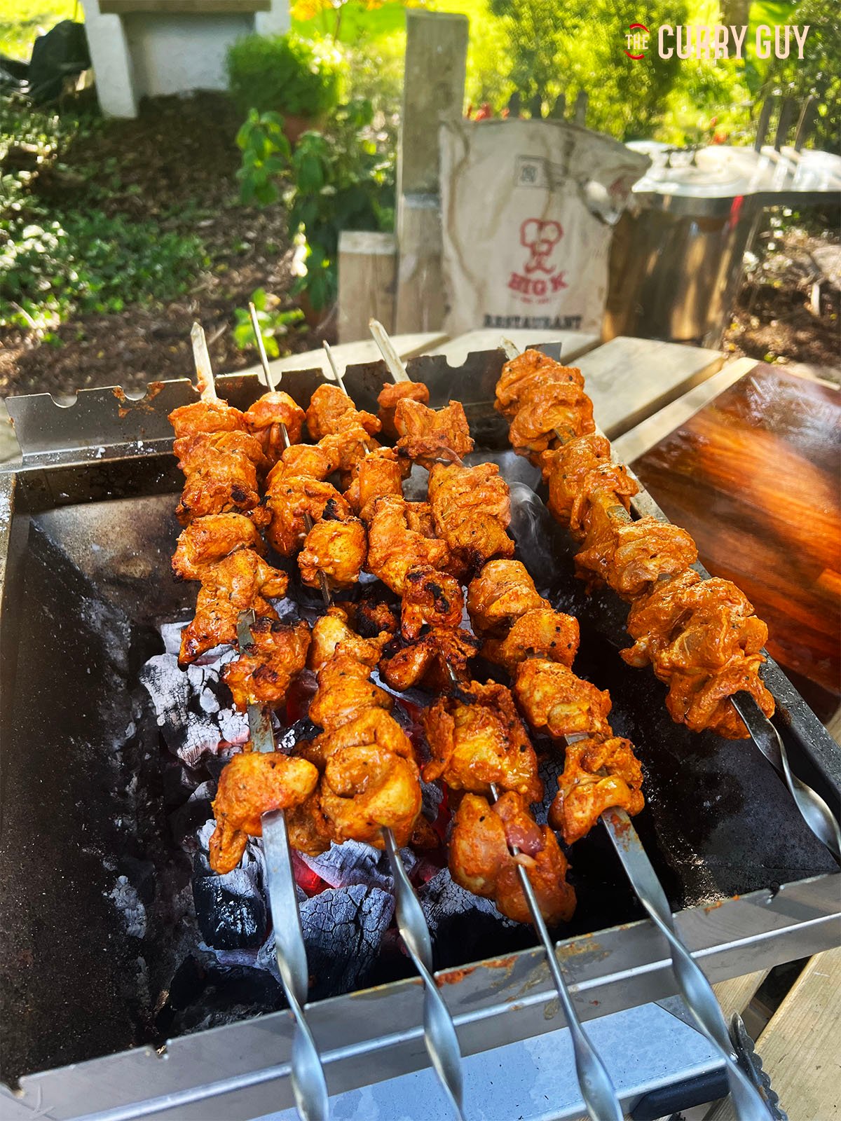 The tandoori chicken tikka cooking on the barbecue/