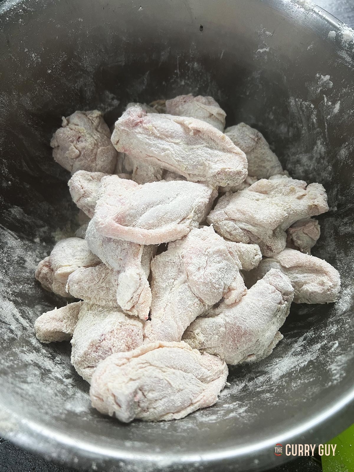 Preparing the chicken wings with salt and pepper and flour.