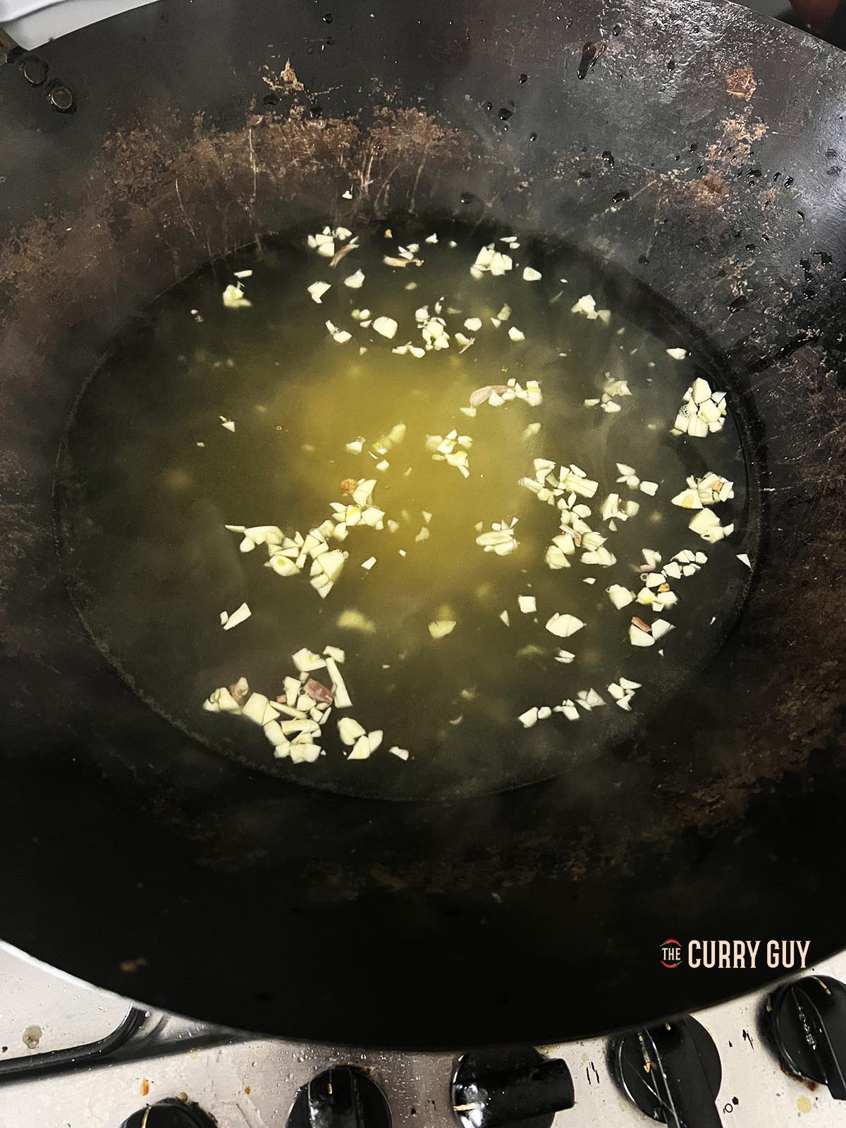 Simmering the garlic and ginger in a wok.