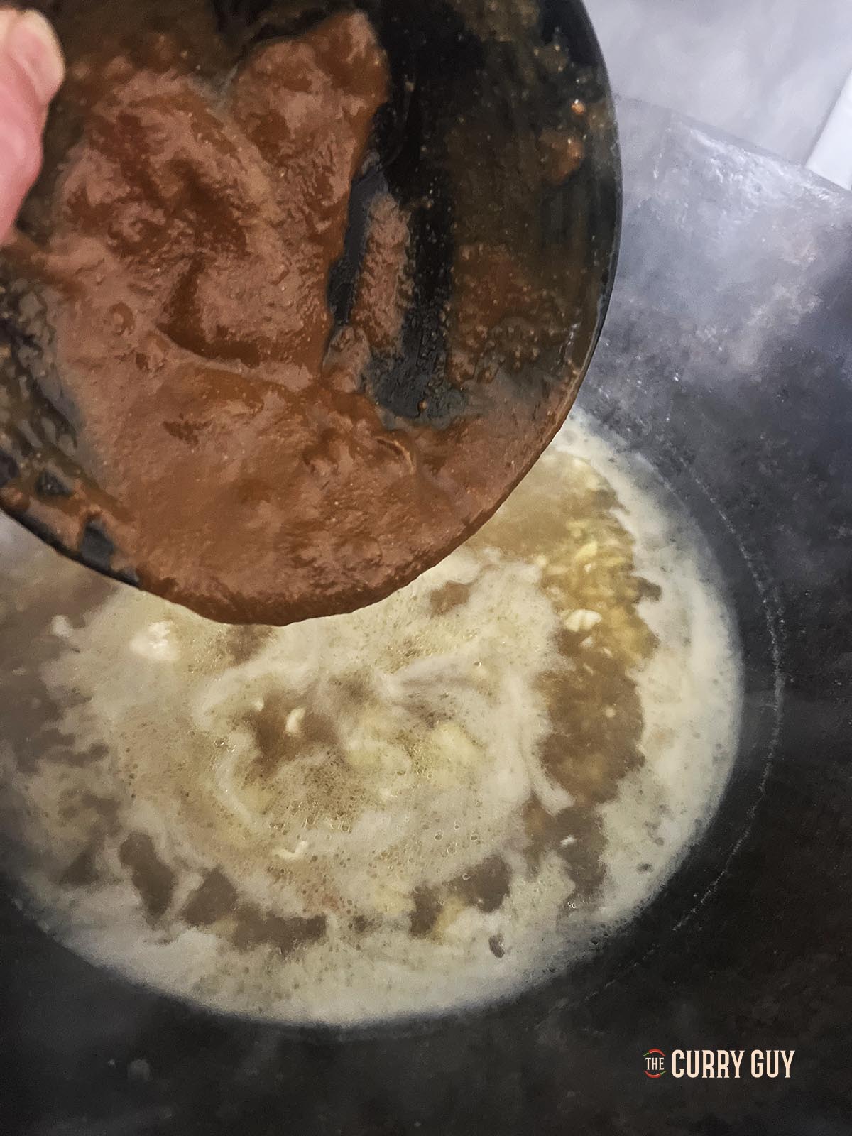 Adding miso paste to the simmering stock