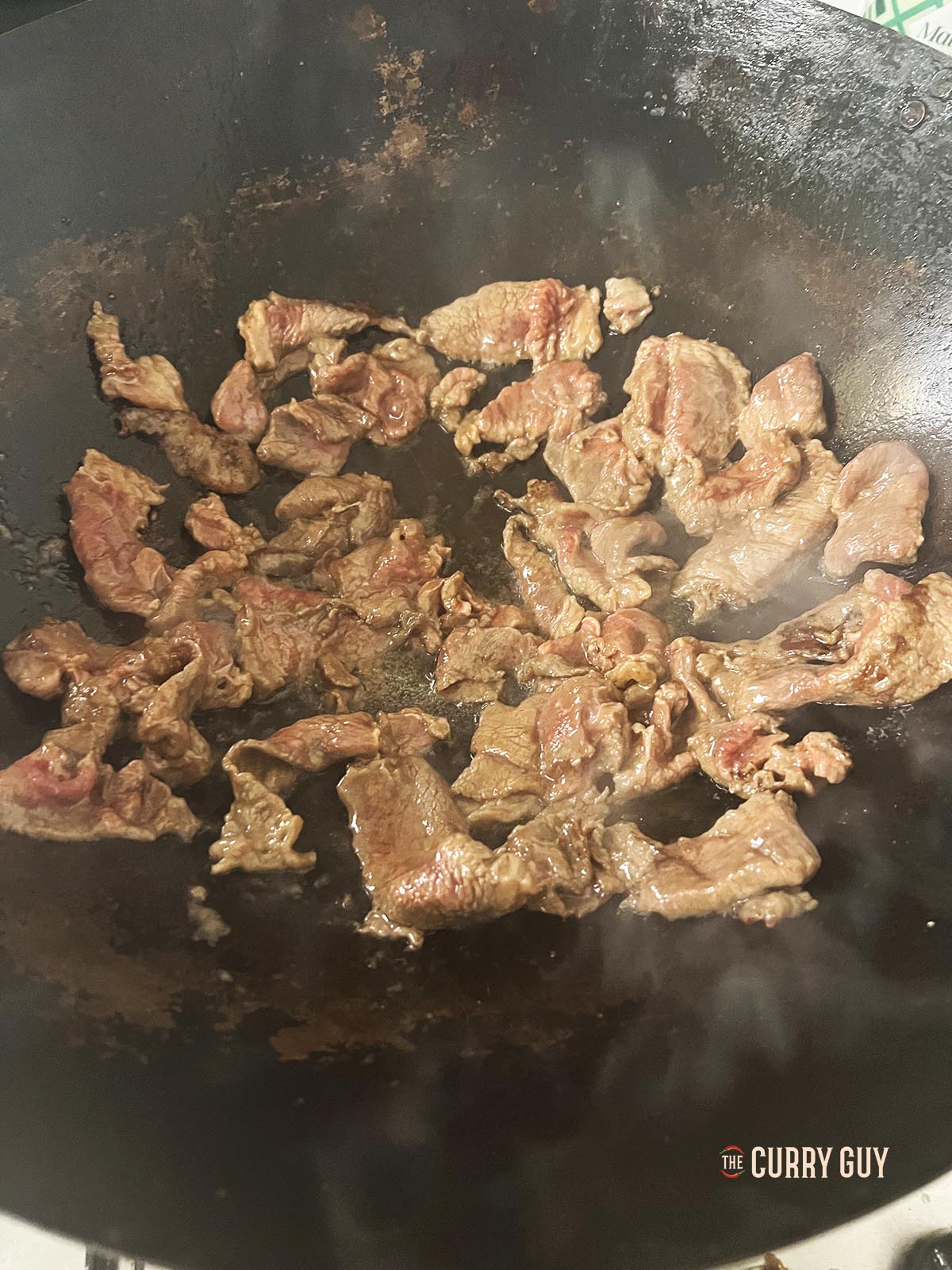 Frying the beef in a wok.