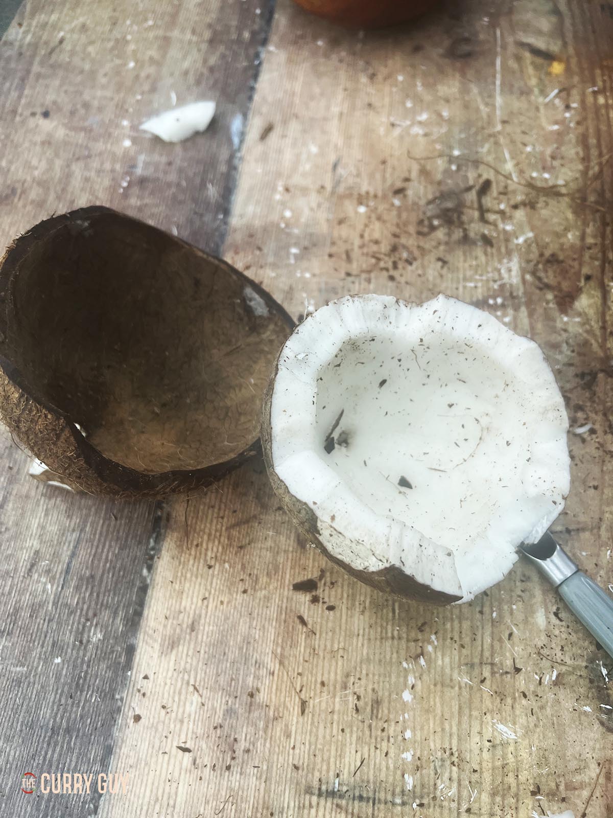 Removing the coconut meat from the shell.