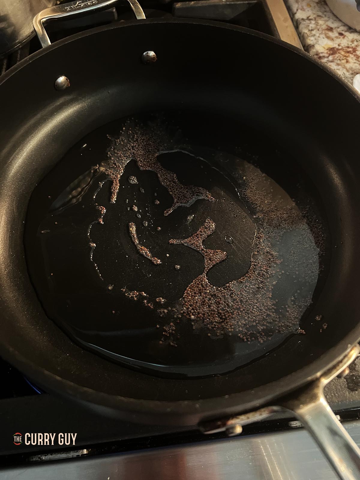 Tempering the mustard seeds in the coconut oil.