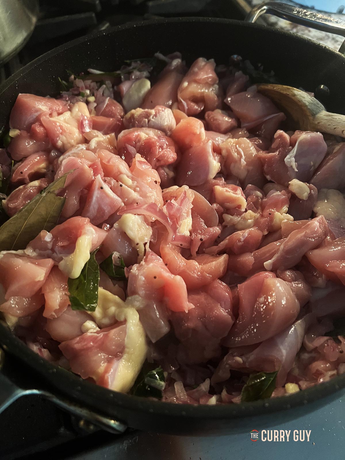 Adding the chicken to the base masala.