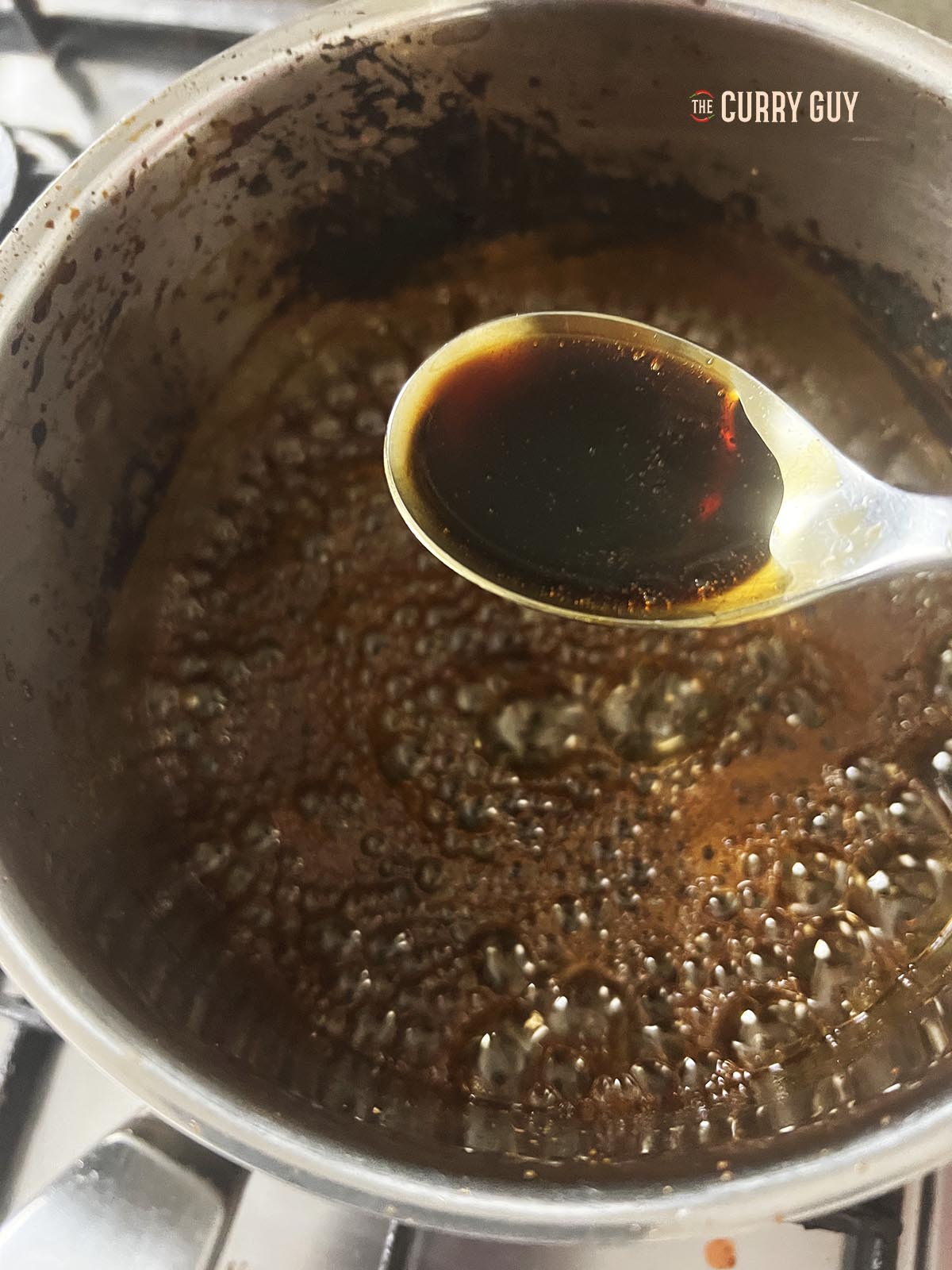 Thickening the sweet soy sauce over a medium heat in a saucepan.