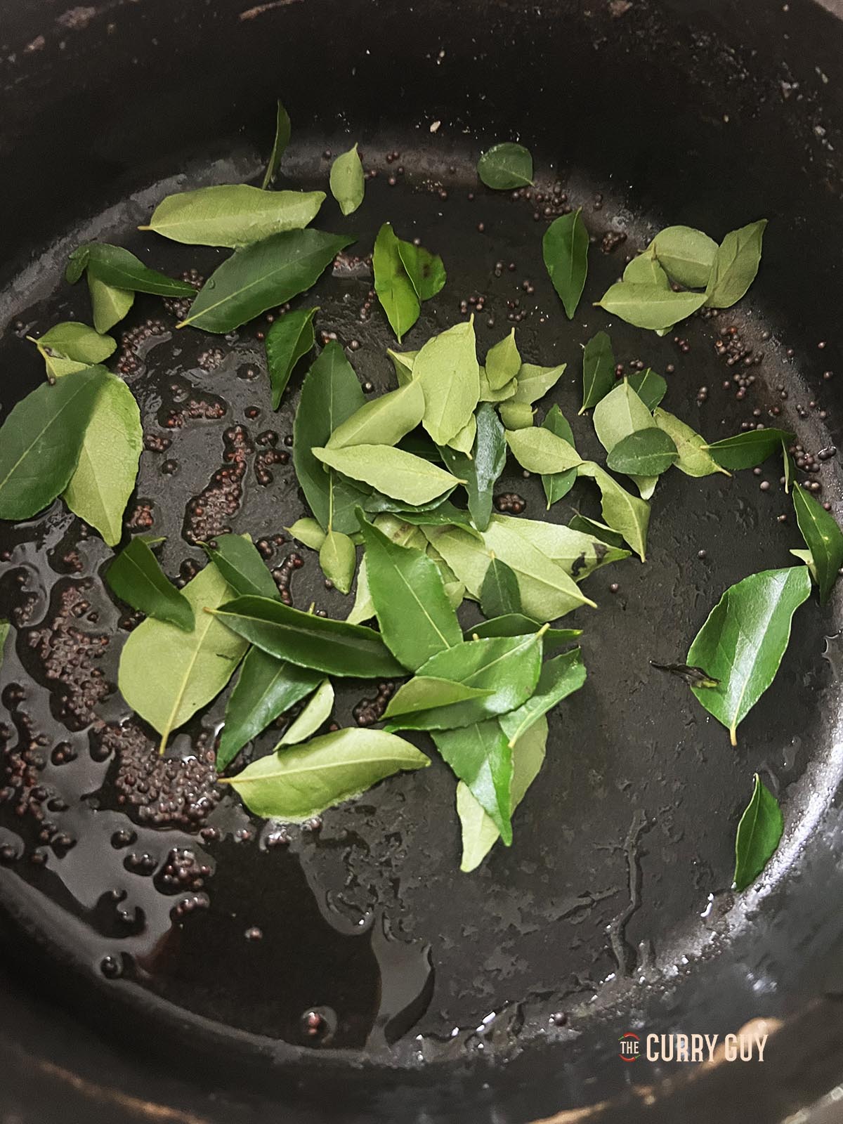 Infusing the mustard seeds and curry leaves into the oil.