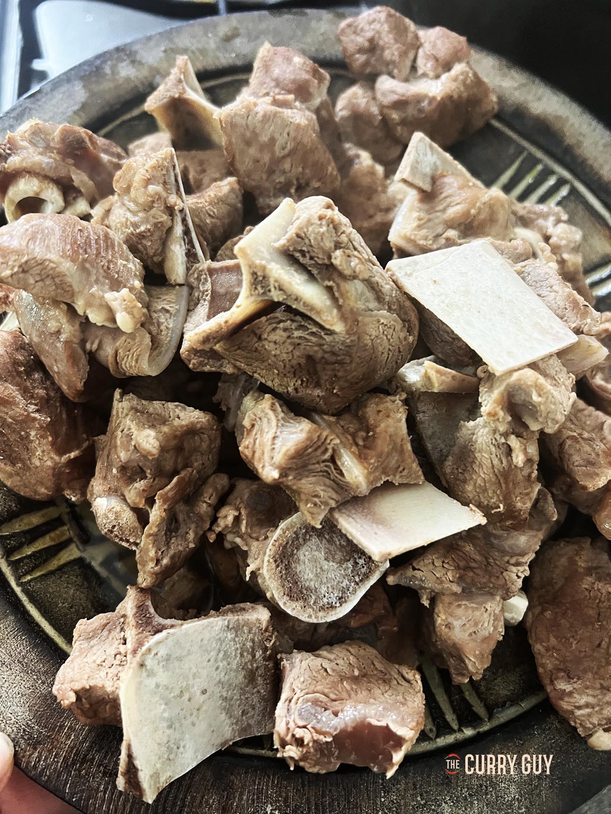 The cooked meat on a plate, ready to be added to the curry.