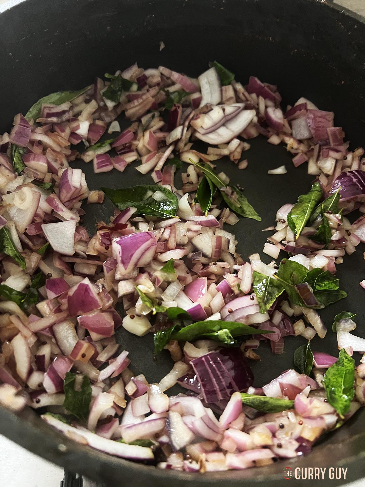 Frying the onion until soft and translucent.