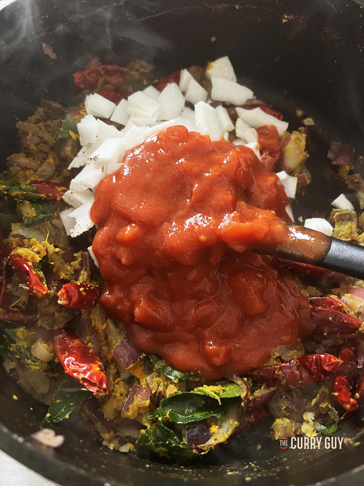 Adding the coconut pieces and chopped tomatoes.