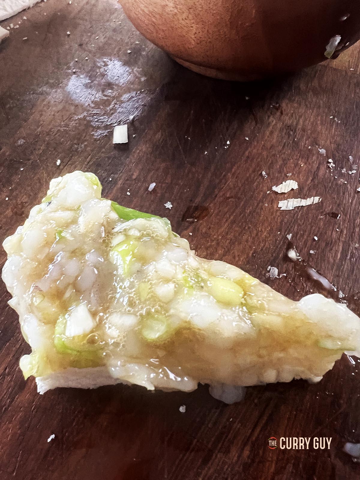 Topping the bread pieces with the shrimp.