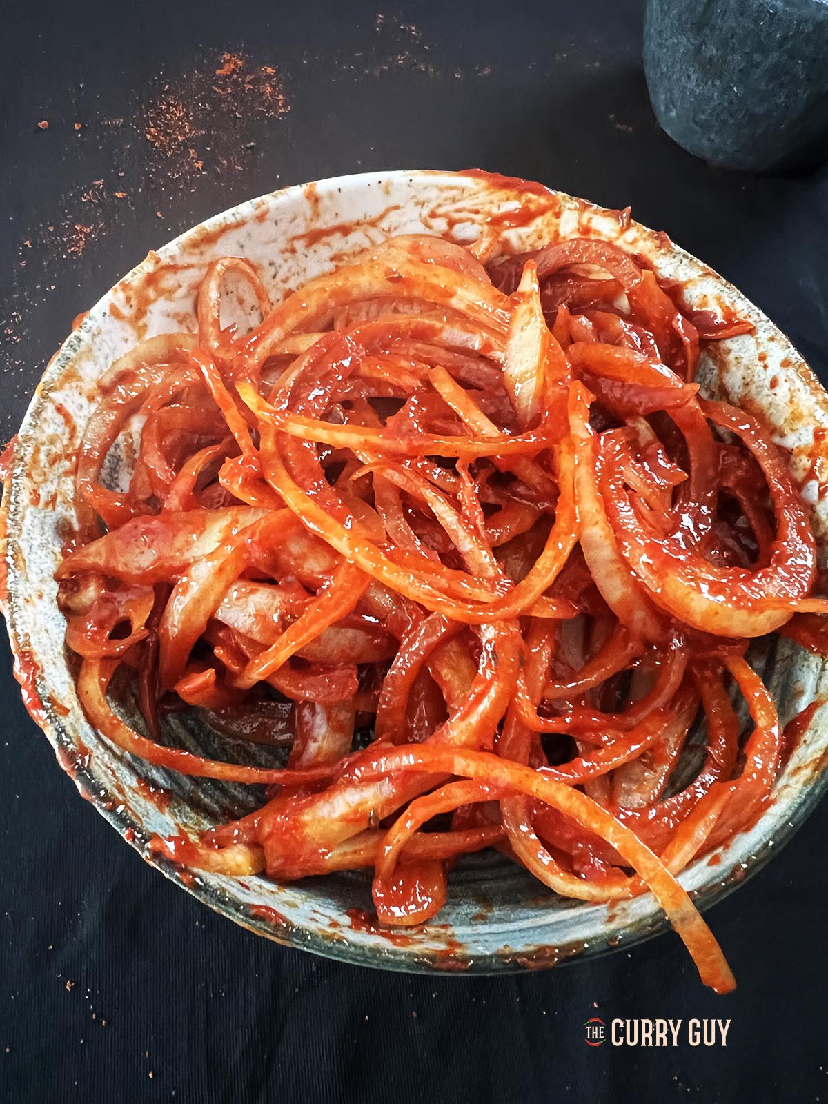 The onion coated with the red dressing.