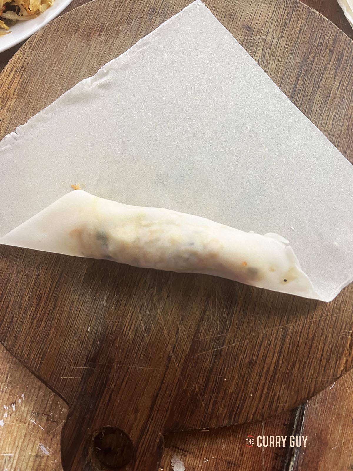 Wrapping the filling in a spring roll wrapper.