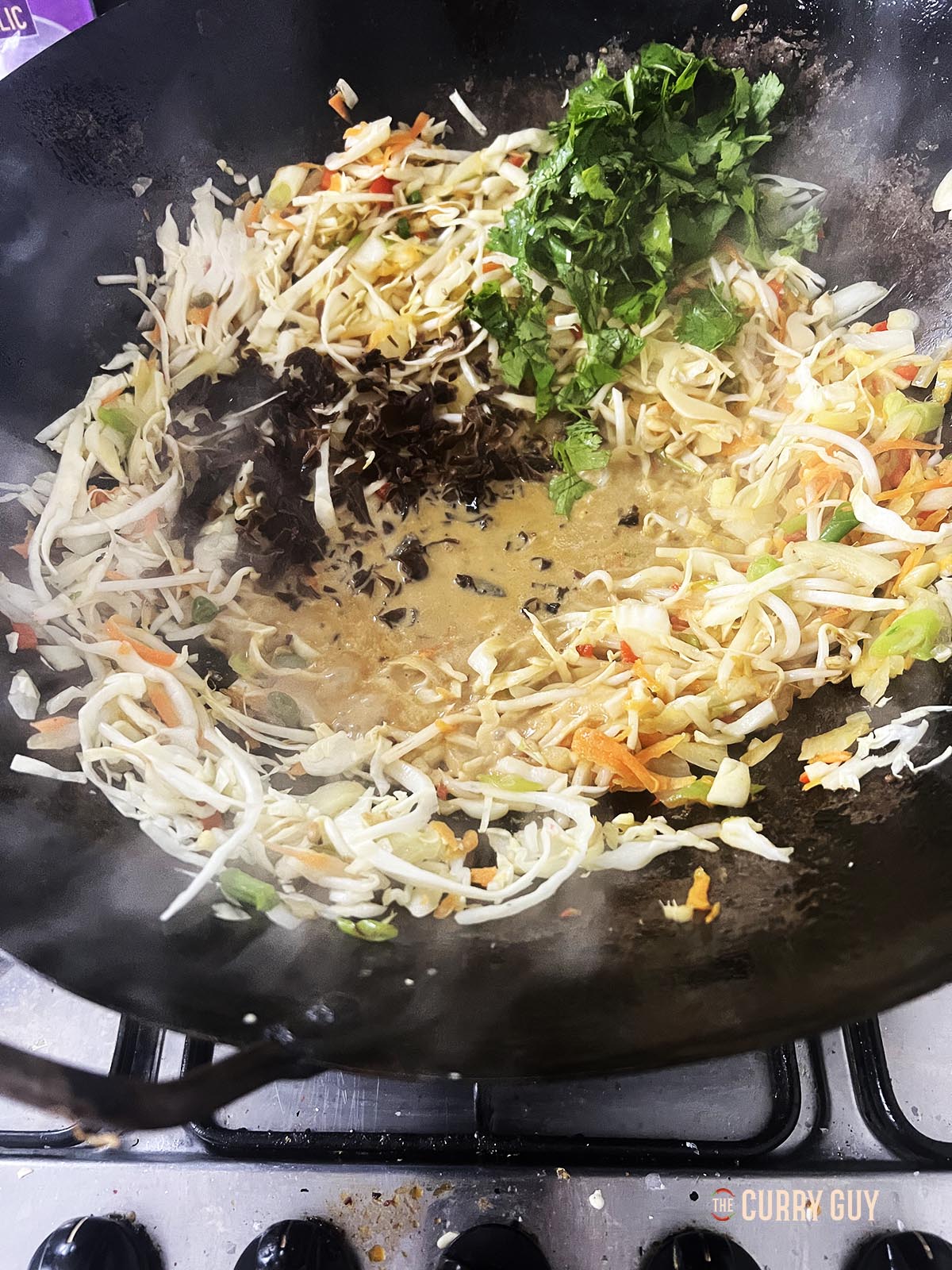 Adding the mushrooms and sesame paste to the wok.
