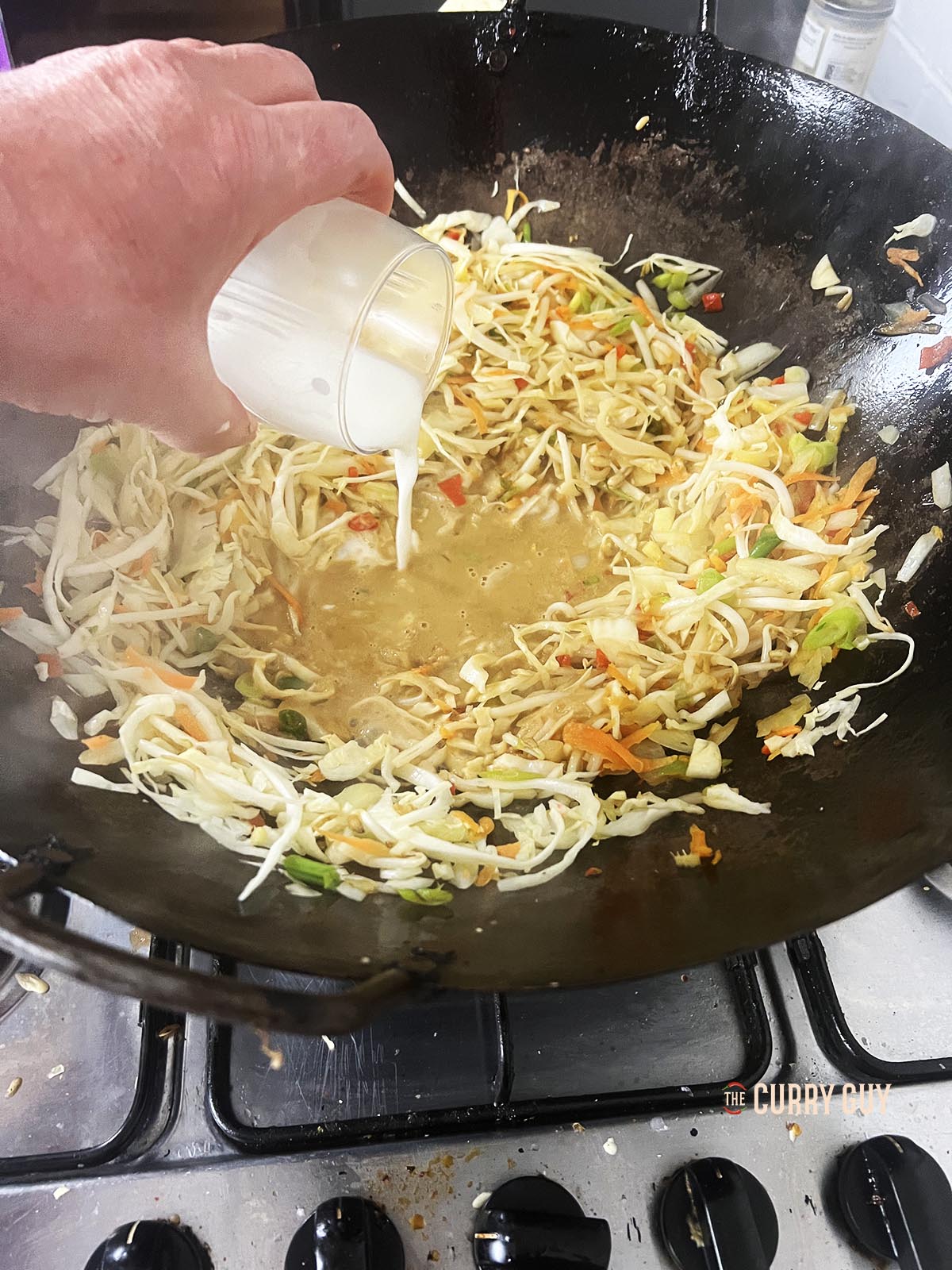 Adding the slurry to the wok.