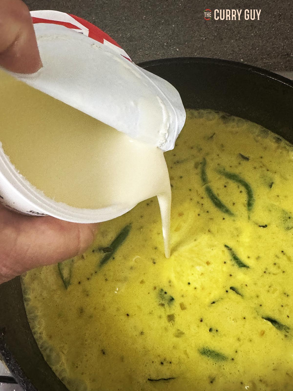 Adding cream to the sauce. 