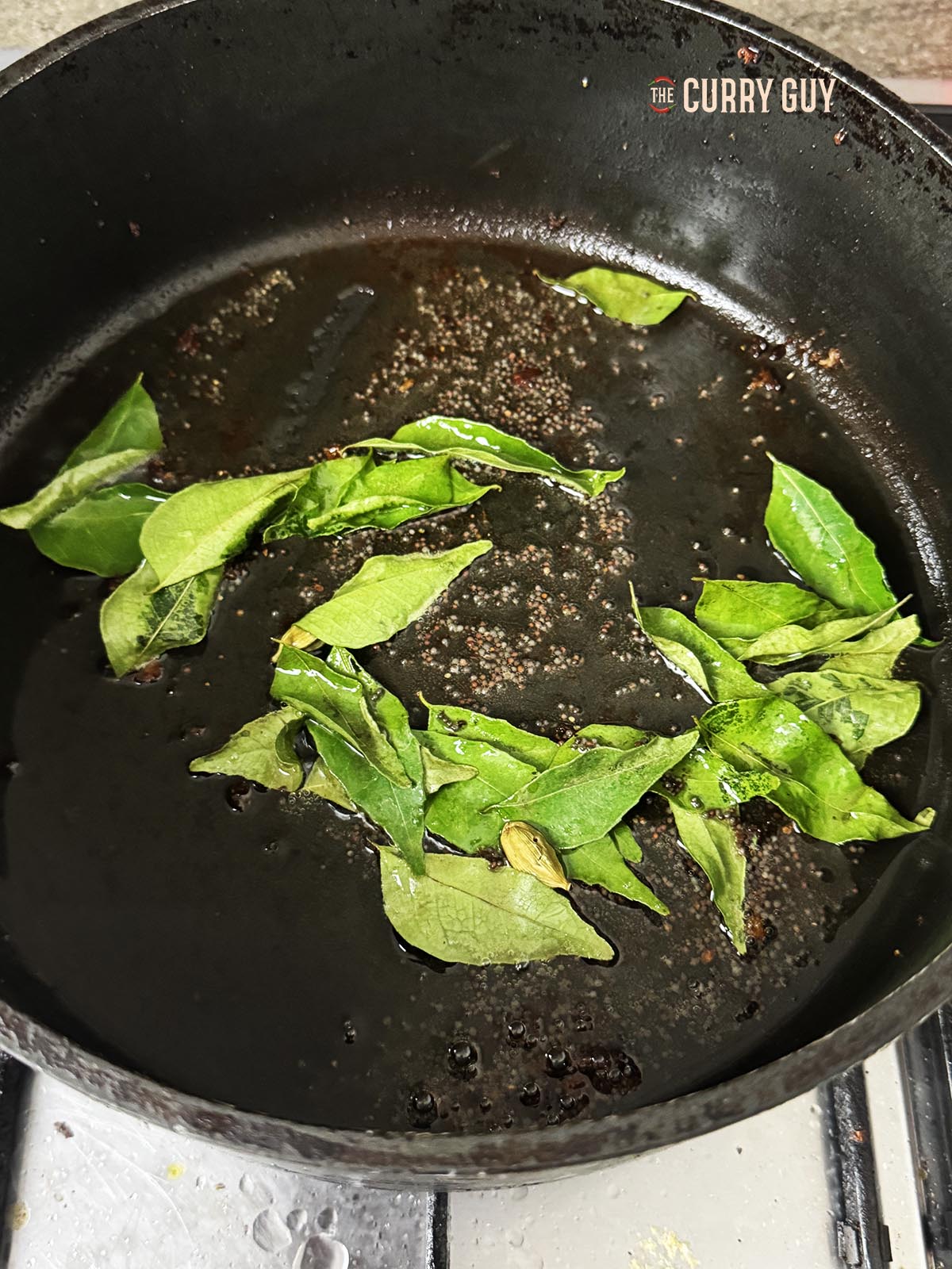 Frying the mustard seeds and curry leaves to infuse their flavour into the oil. 