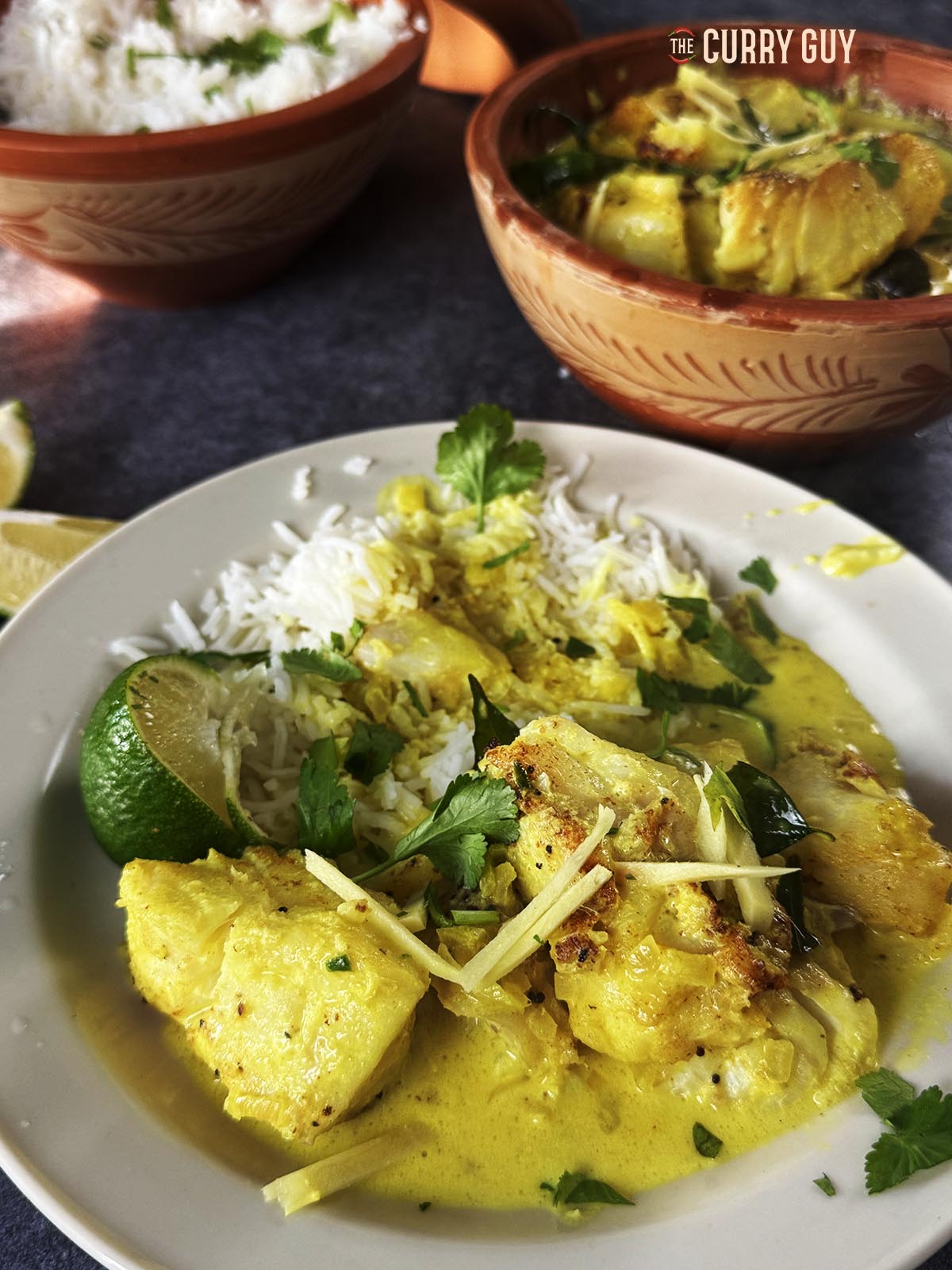 Coconut cod curry on a serving plate with rice on the side.