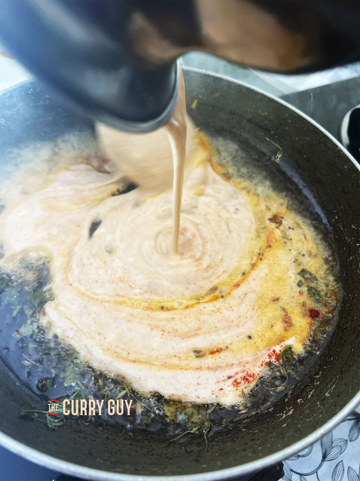 Pouring the yoghurt into the pan. 